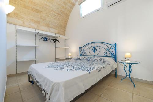 佩斯科勒海滨Villa Lantana by SALENTOLTREMARE的一间卧室配有一张带蓝色和白色床单的床。