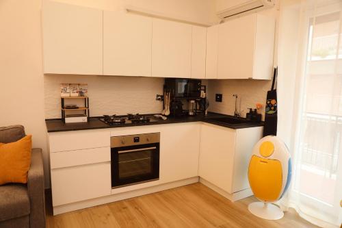 a kitchen with white cabinets and a stove top oven at Le Rotte di Antonella in Lido di Ostia