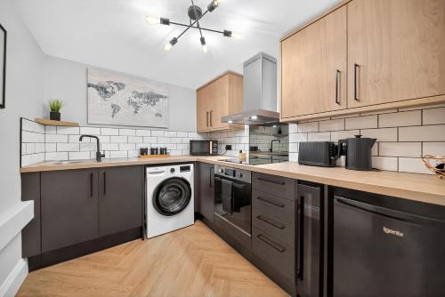 a kitchen with a washer and dryer in it at Rosemont ApartHotel in Leeds