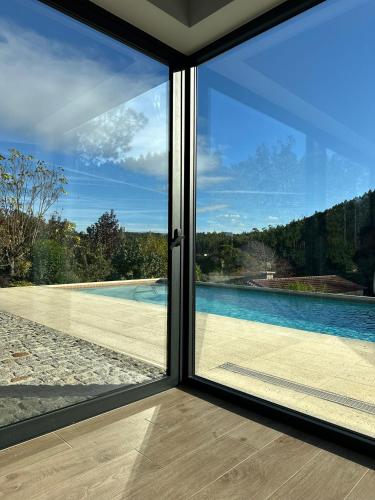 a sliding glass door with a view of a swimming pool at Quinta da Barrosa - Arouca in Arouca