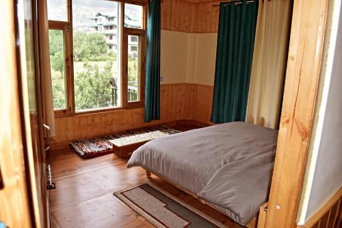 um quarto com uma cama em um quarto com janela em Ghar Homestay em Kulu