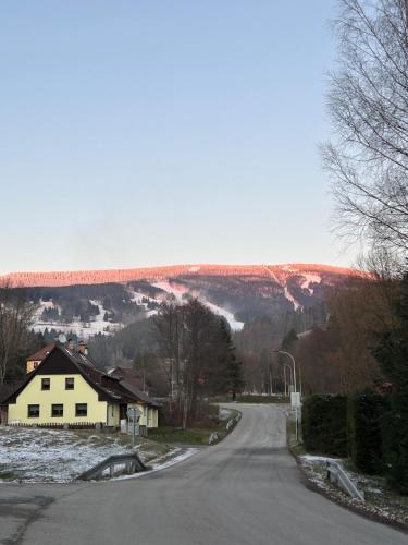an empty road with a house and a bridge in the background at Apartmán pod sjezdovkou Lysá Hora Horní náměstí Ski Lumi in Rokytno