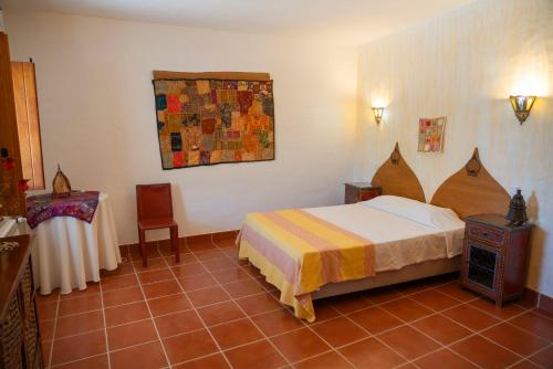 a bedroom with a bed and a table in it at Casa d'Aldeia in Rio Maior
