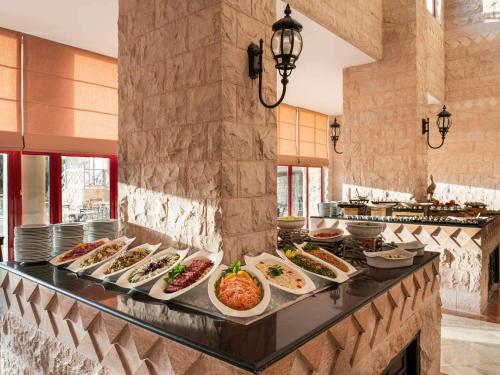Grand Mercure Petra في وادي موسى: بوفيه مع العديد من أطباق الطعام على منضدة