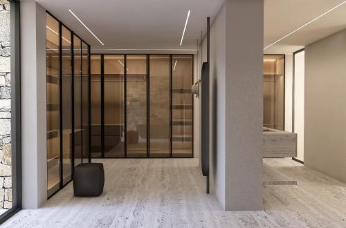 ein leerer Flur mit Glastüren und ein Koffer in der Unterkunft Kenshō Paros in Krotiri