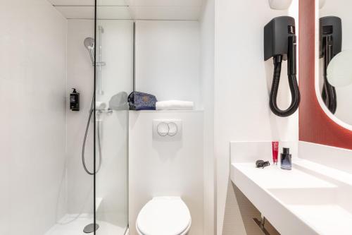 um banheiro com chuveiro, vaso sanitário e pia em ibis Paris Porte de Montreuil em Paris