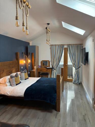a bedroom with a large bed with a blue blanket at The Forge Guest Rooms in Long Whatton