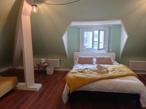 um quarto com uma cama com um bicho de pelúcia em Les Bulles B&B em Épinal