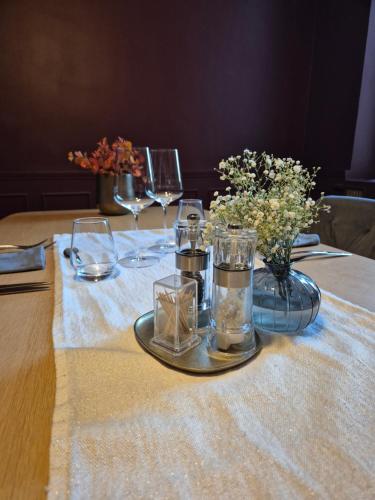 uma mesa com taças de vinho e flores sobre uma mesa em Les Bulles B&B em Épinal