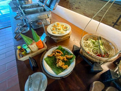 a table with a plate of food and other foods at Chumphon Cabana Resort in Chumphon