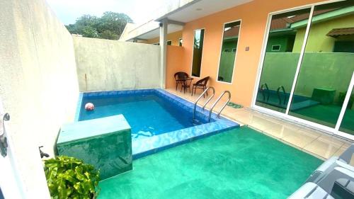 a small swimming pool in the backyard of a house at Capital O 91246 Tokman Inn in Pantai Cenang