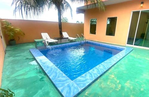 a swimming pool in front of a house at Collection o Langkawi near pantai cenang formerly tokman inn in Pantai Cenang