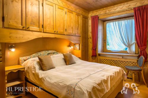 una camera da letto con un letto e una finestra di Suite Villa Francesca a Cortina dʼAmpezzo