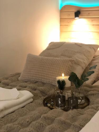 a bed with a table with a candle on it at Elf apartment in Rovaniemi