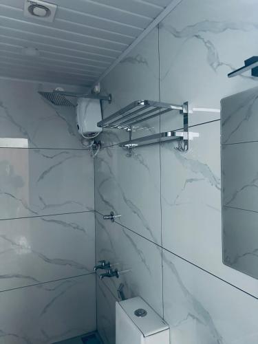 a bathroom with a shower and a toilet and a mirror at RKM Pearl in Cochin