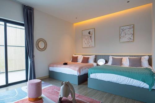 een slaapkamer met twee bedden en een raam bij About P พูลวิลล่า ชะอำ in Ban Phu Wai