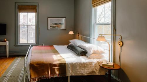 The Ipswich Inn في إبسوتش: غرفة نوم بسرير وطاولة ونوافذ