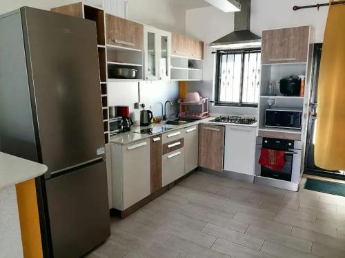 uma cozinha com armários brancos e uma geladeira de aço inoxidável em Idyllic Villa in Pereybere with Private Pool em Pereybere