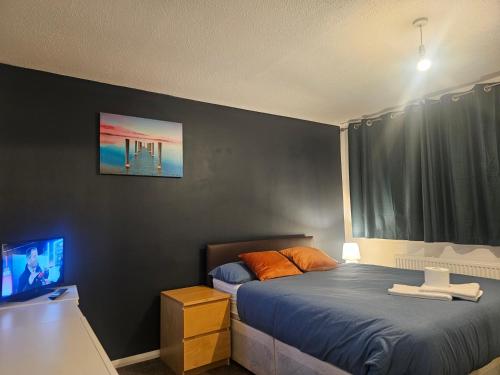 a bedroom with a bed and a tv in it at Rosag Guest House Rainham in Rainham