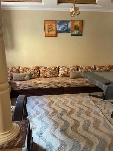 a living room with a long couch on a wall at Rest in Agadir