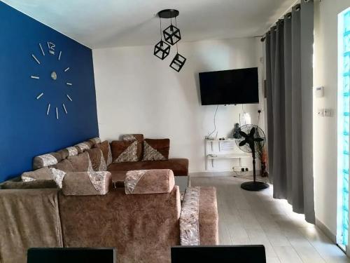 uma sala de estar com um sofá e um relógio na parede em Idyllic Villa in Pereybere with Private Pool em Pereybere