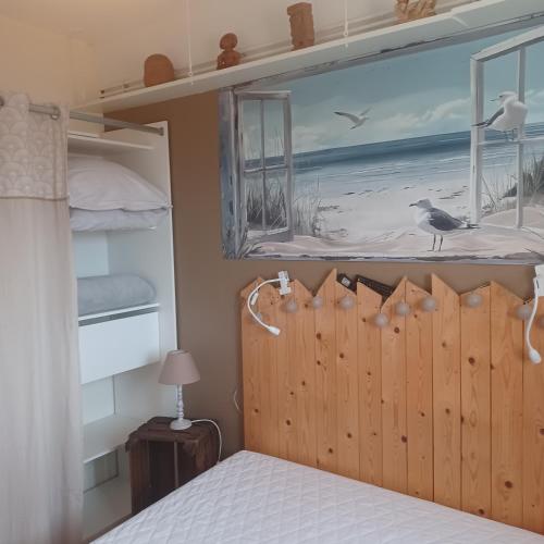 a bedroom with a bed and a picture of a beach at Apt cosy dans maison de charme in La Rochelle
