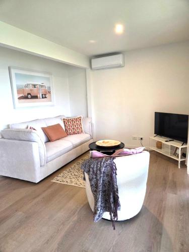 a living room with a couch and a tv at Jalpari in McCrae