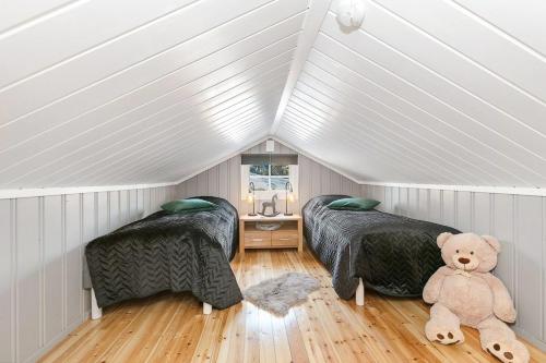 a attic bedroom with two beds and a teddy bear at Family Cabin With Stunning Views At Sjusjøen in Eggedal
