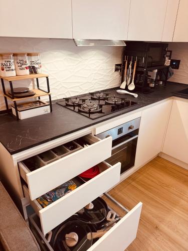 a kitchen with white cabinets and a stove top oven at Le Rotte di Antonella in Lido di Ostia