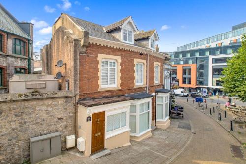 an old brick building on a street at Luxury Three Bedroom Duplex Apartment Torquay Marina in Torquay