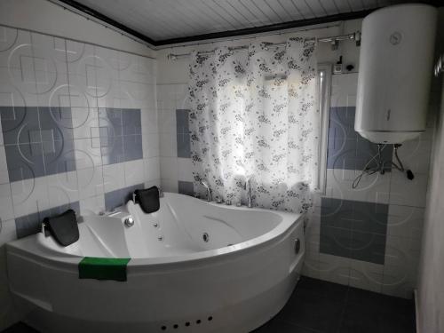 een wit bad in een badkamer met een douche bij Chez Lalie in Mandriankeniheny