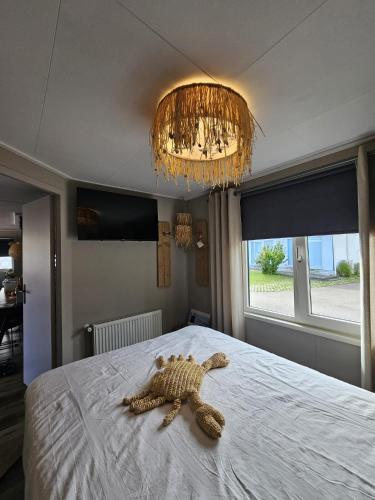 a stuffed turtle laying on a bed in a bedroom at Chalet 138 lodge in Sint Annaland