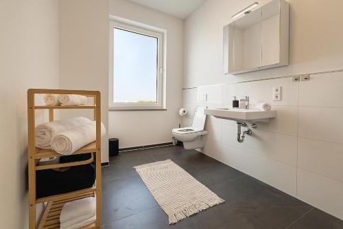 Un baño blanco con lavabo e inodoro. en Stadtwohnung in Siegen-Zentrum, en Siegen