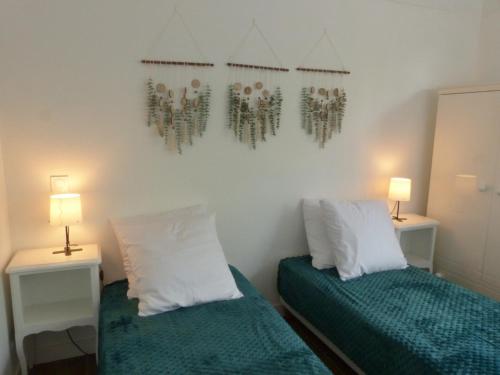 two beds in a room with two lamps on the wall at Séjour indépendant et autonome chez l'habitant avec petit-déjeuner inclus in L'Ile d'Yeu