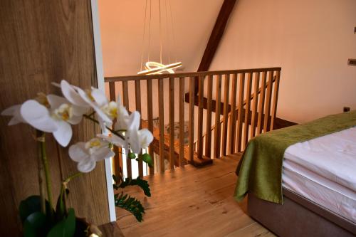 una stanza con un letto e una scala con fiori bianchi di Resort Village Majer - Bela krajina a Gradac