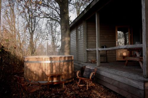 a barrel sitting on the porch of a cabin at For-Rest Lodge de Hilkensberg in Broekhuizen