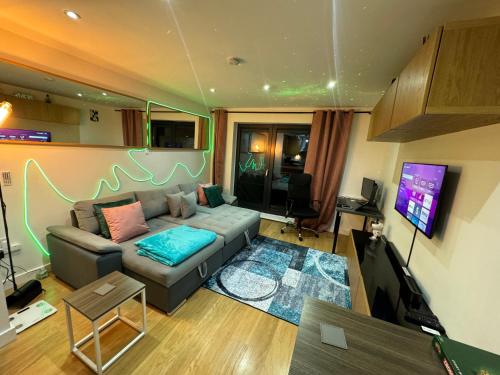a living room with a couch and a flat screen tv at The Windy Smart Home, you will love it in Grays Thurrock