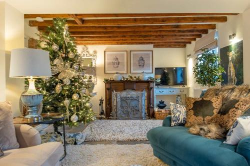 Hiron's Piece - Hot Tub Packages Available في Weston Subedge: غرفة معيشة مع شجرة عيد الميلاد وأريكة زرقاء