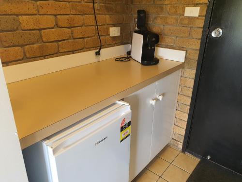 a counter top with a microwave sitting on top of it at Bellbrae Motel in Torquay