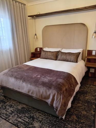 a bedroom with a large bed and a large window at Melkbos Corner in eMalahleni