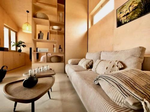 a living room with a couch and a table at La Cabane du Pêcheur, Clim et bord d'étang! in Pérols