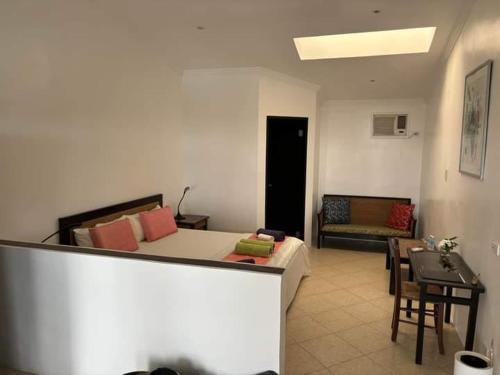 Panorama de Argao Boutique Hotel في Argao: غرفة معيشة بها سرير وأريكة