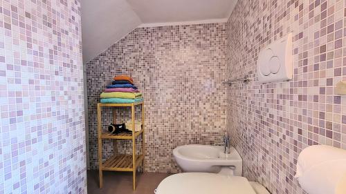 a bathroom with a toilet and a sink at Maya Suite & Garden in Sarteano