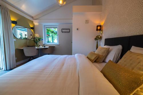 a bedroom with a large white bed and a desk at B&B Natuurlijk Harderwijk in Harderwijk
