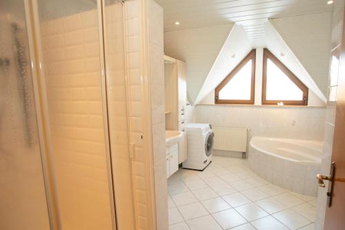 HopfmannsfeldFerienwohnung Heike的带水槽、浴缸和窗户的浴室