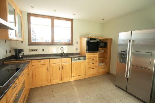 HopfmannsfeldFerienwohnung Heike的厨房配有木制橱柜和不锈钢冰箱