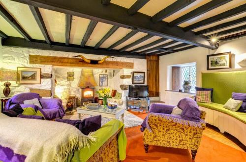Un dormitorio con muebles morados y una pared de piedra. en Ty Uchaf, en Dolbenmaen