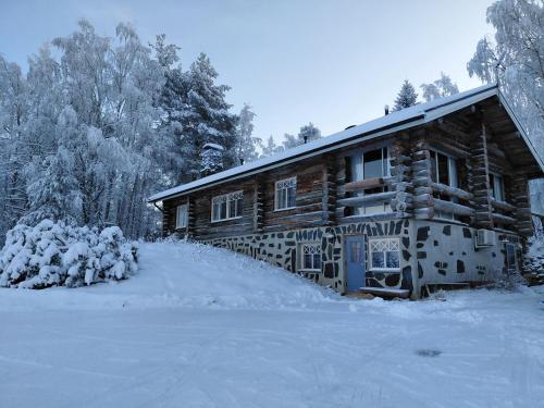 ein Blockhaus im Winter mit Schnee auf dem Boden in der Unterkunft A room (or 2 or 3) in a Lapland House of Dreams in Rovaniemi