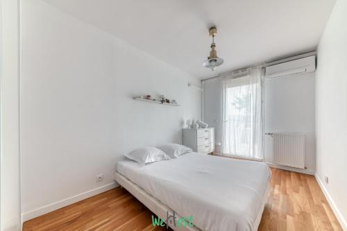 a white bedroom with a bed and a window at Vinatier - Lyon 2 - LB - Large family apartment with parking in Lyon in Bron