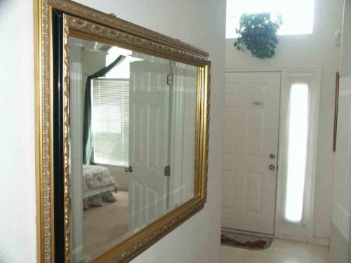 a mirror with a gold frame in a room at Lake Berkley 5 bedrm 3 bath villa near Disneyland in Kissimmee